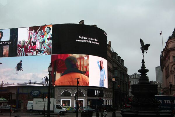 Curved digital screens at a busy intersection